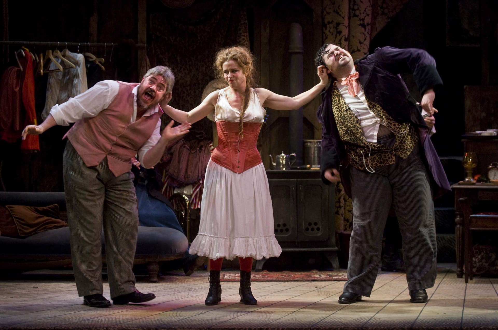 A woman pulling two men by their ears