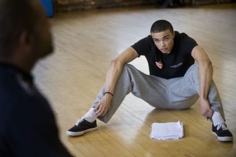 A male actor sat on the floor with a script