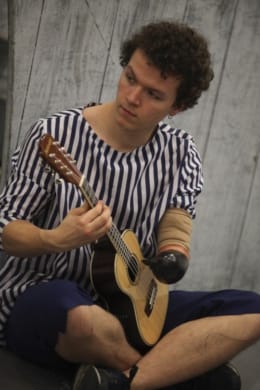 An actor playing the ukuele