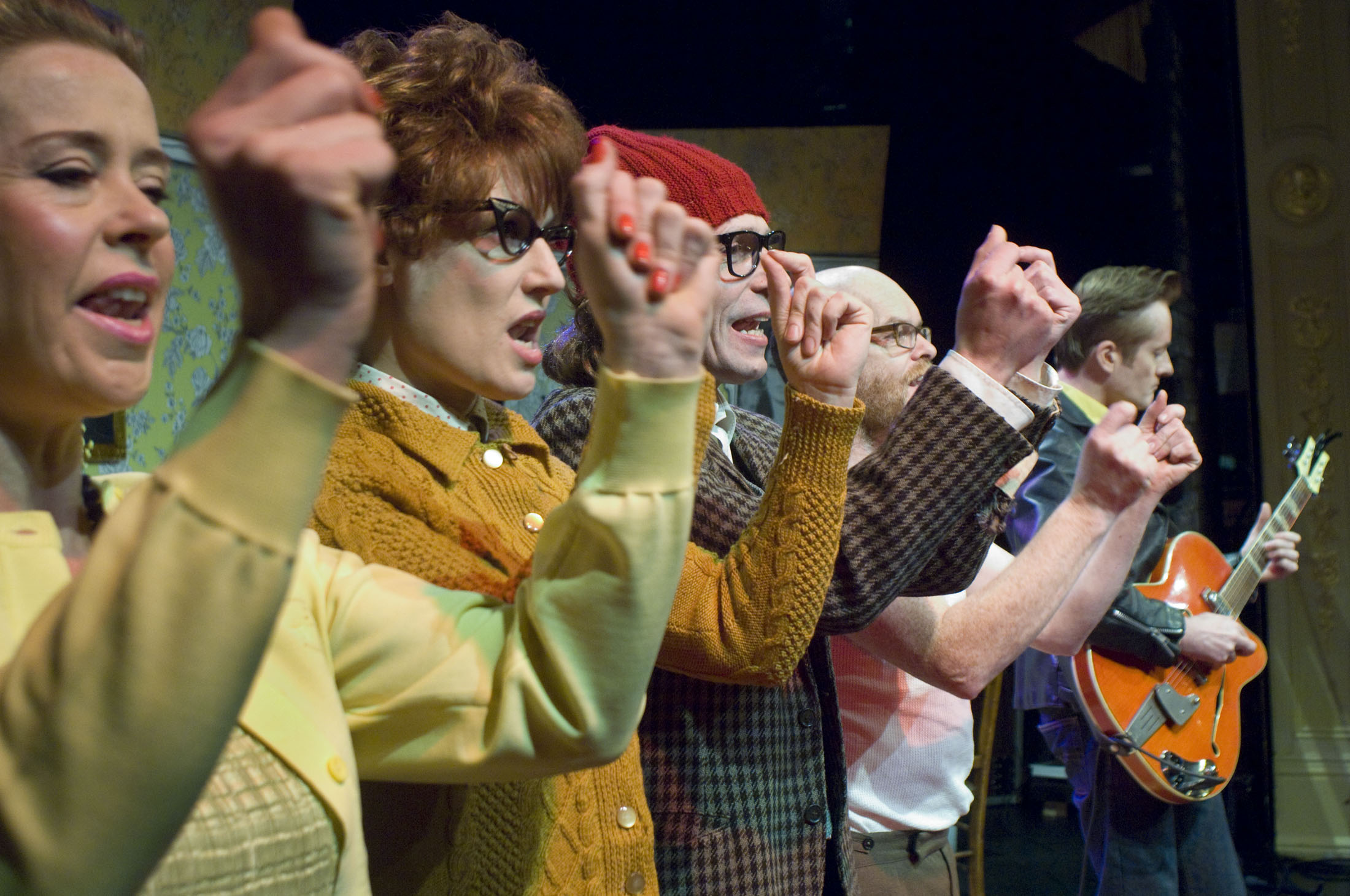 A cast in 50s clothing stood in a line clicking their fingers