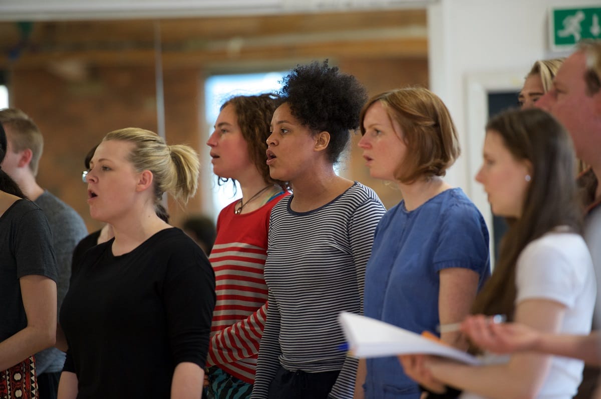 Cast in rehearsals, in a studio.