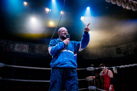 A coach making an announcement in a wrestling ring