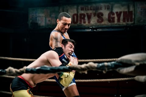 A wrestler gleefully holding another in a tight headlock