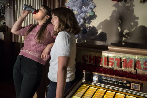 Two girls. One of them drinking.