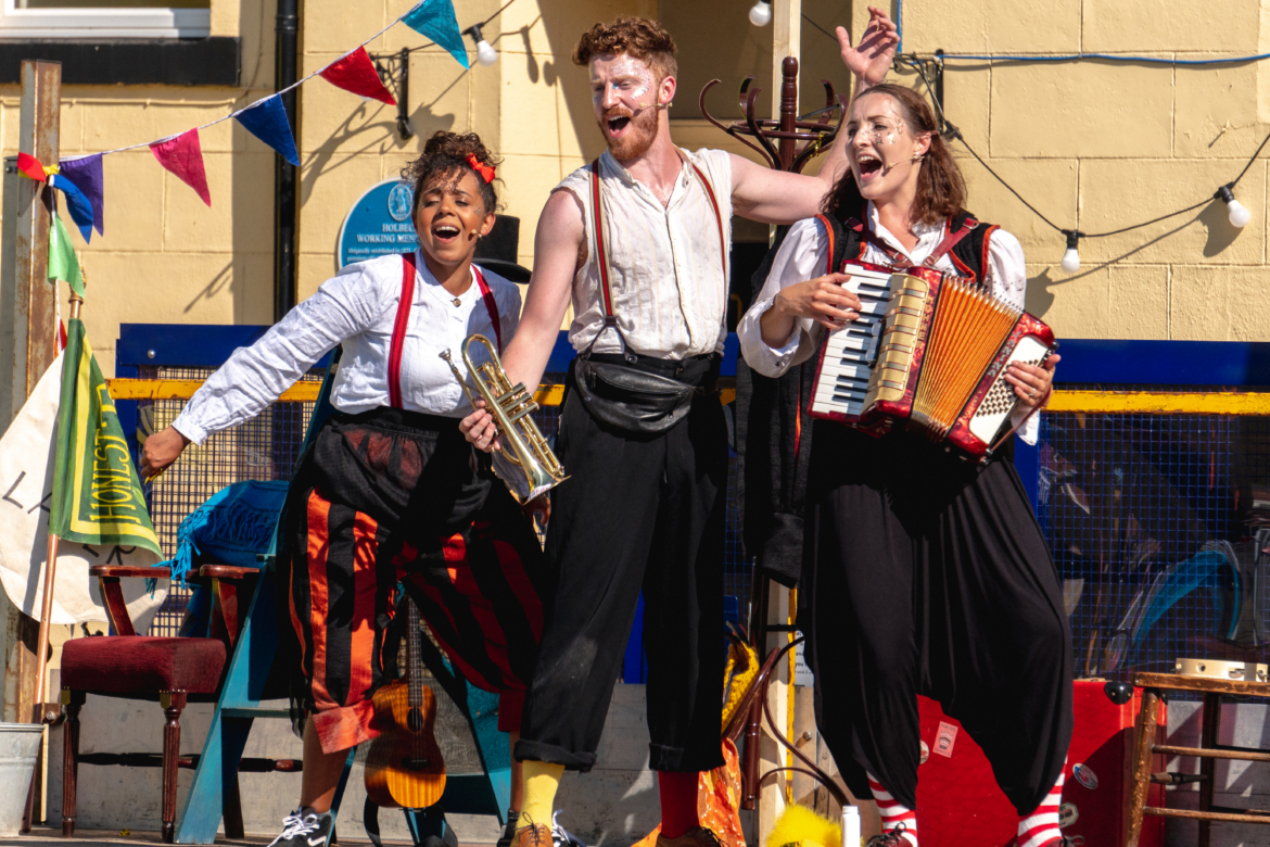 Three people on the back of a truck performing outside a working men's club