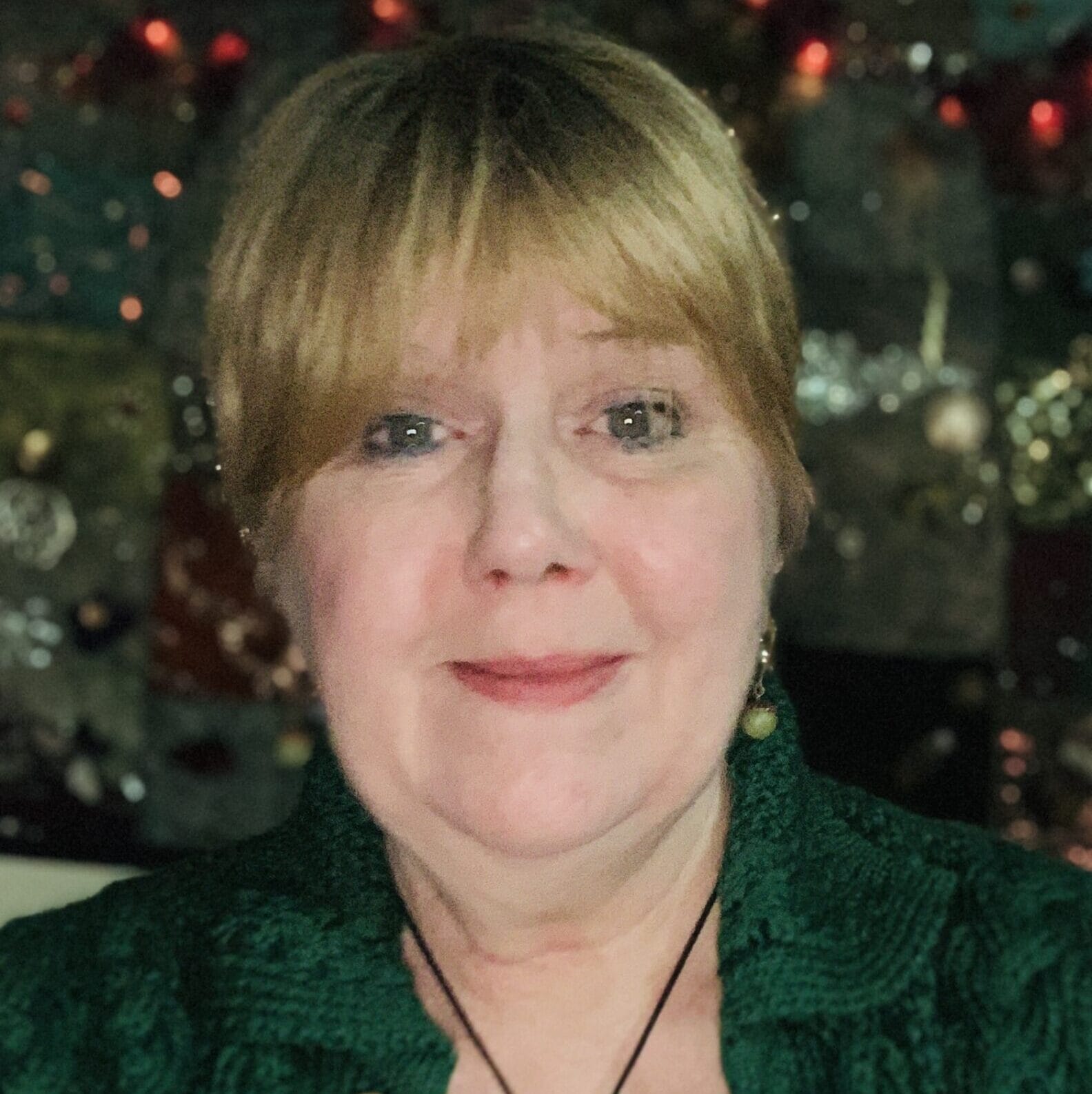 Janet looking festive in front of a Christmas tree
