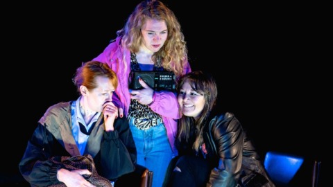 Three sisters crowded round a radio listening to the news