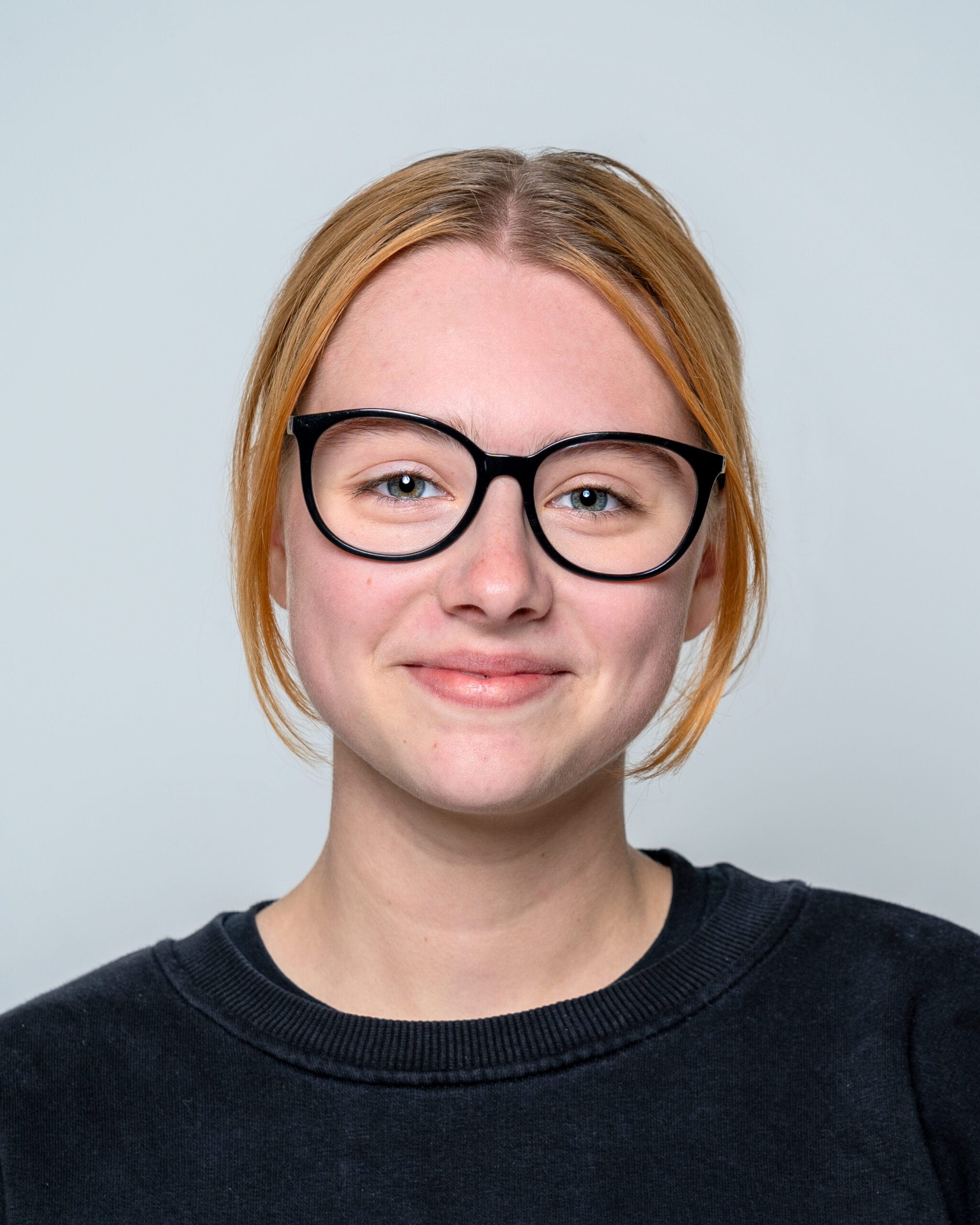 A smiling Rosie with light red hair and glasses