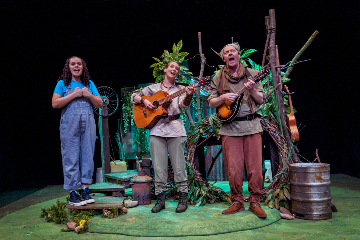 A young girl watches two of Robin Hood's merry men playing guitar and singing
