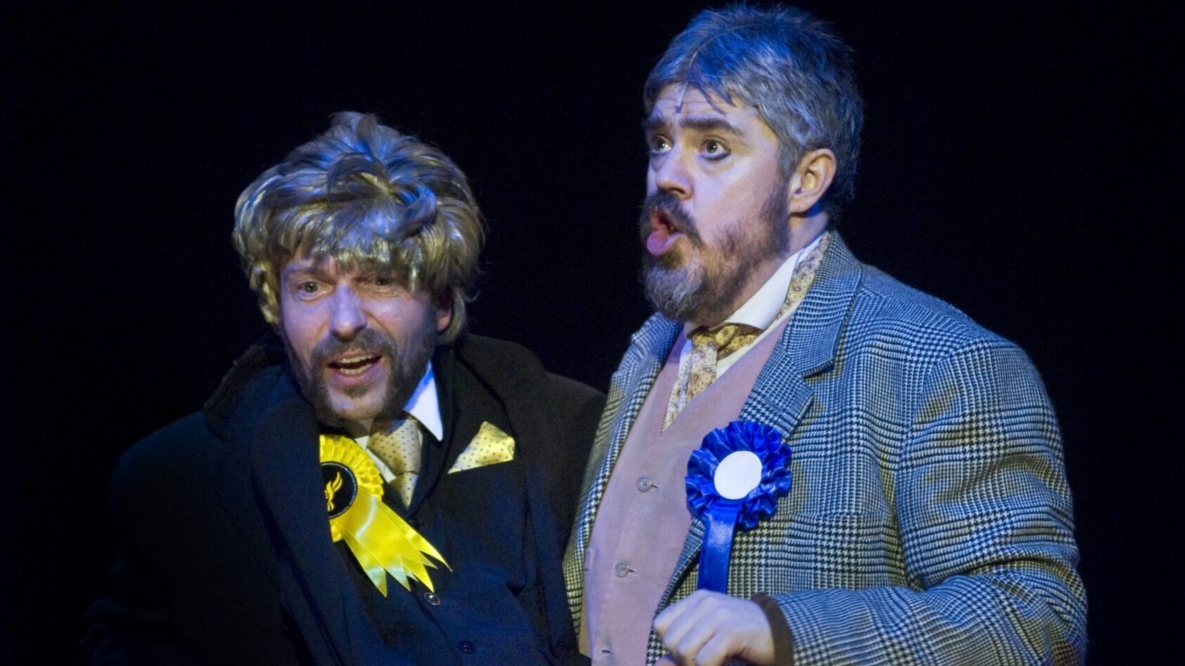 A man holding a mannequin puppet with an actor as its head.