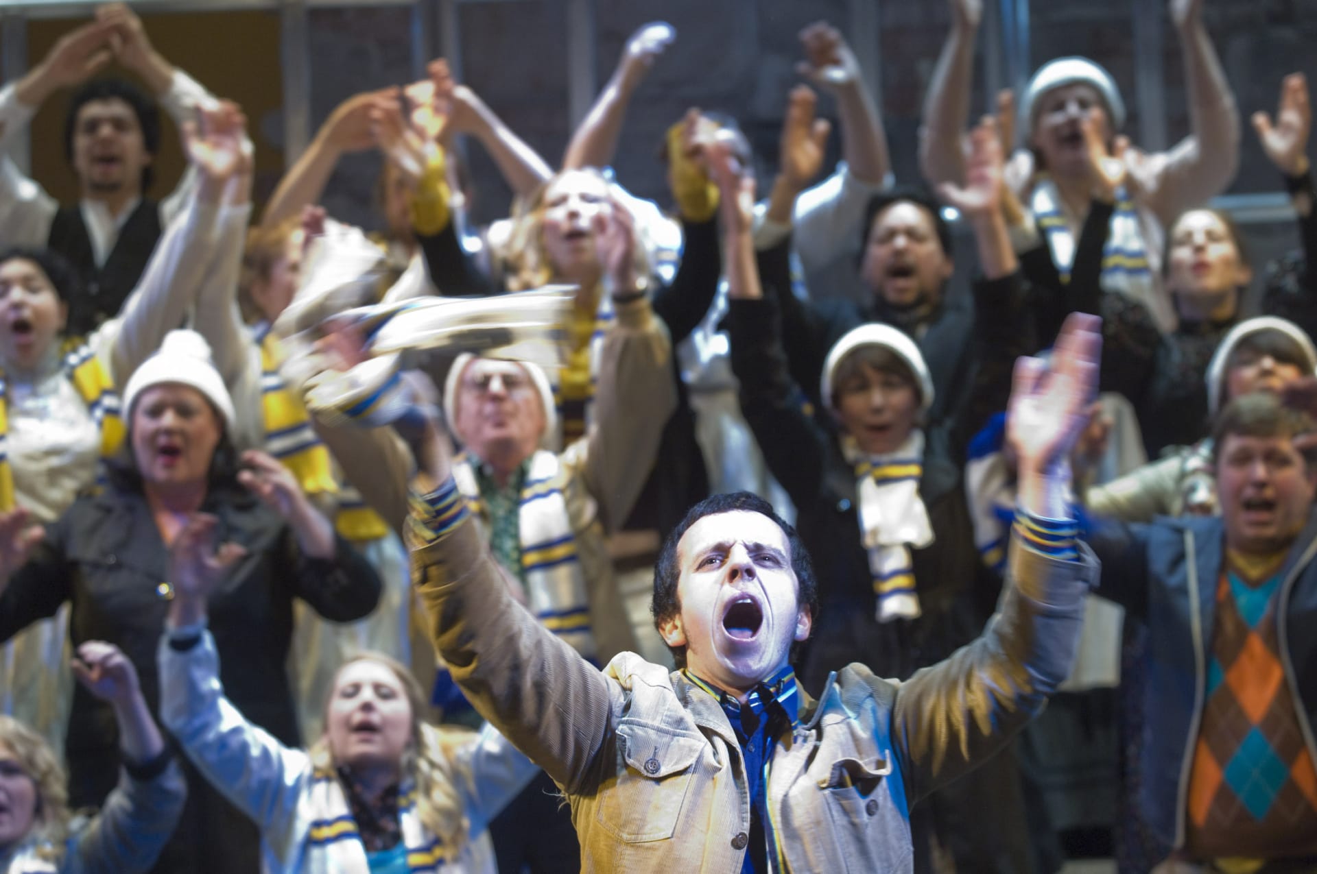 A football crowd with arms stretched in full song