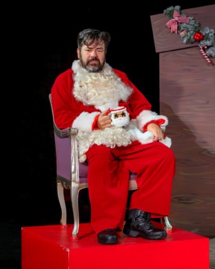 A grumpy sat without beard and hat having a cup of tea on a throne