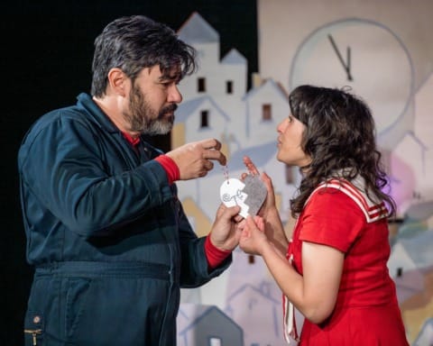 A man and woman joining together two pieces of a heart