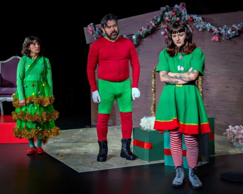 Three Christmas grotto characters looking at a sad elf