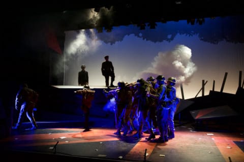 A group of people, listening to one person, who is stood above them