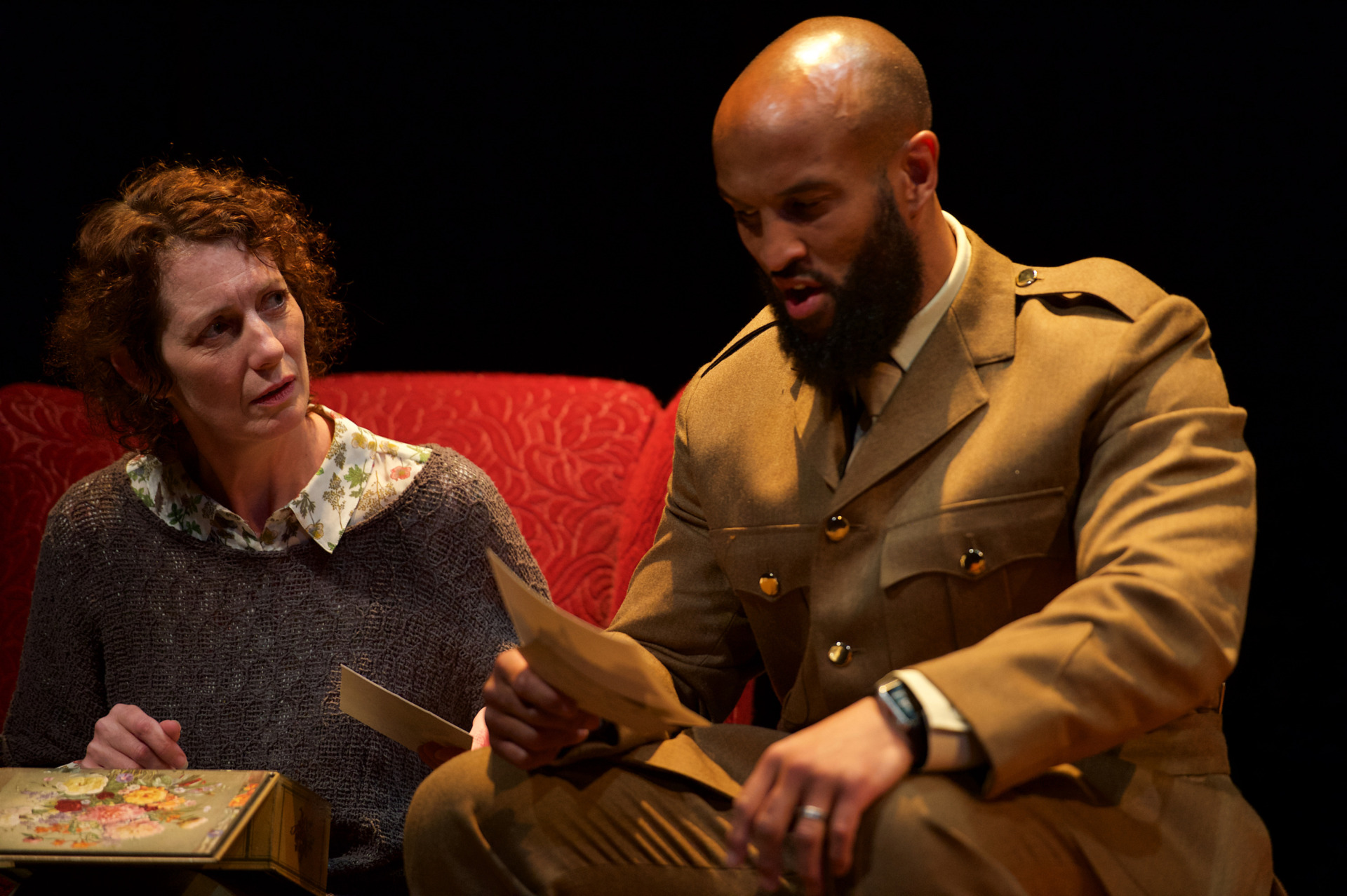 A woman passing a soldier a letter to read