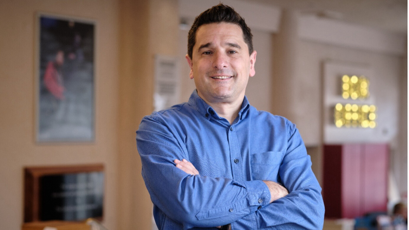 Paul stood smiling with arms folded