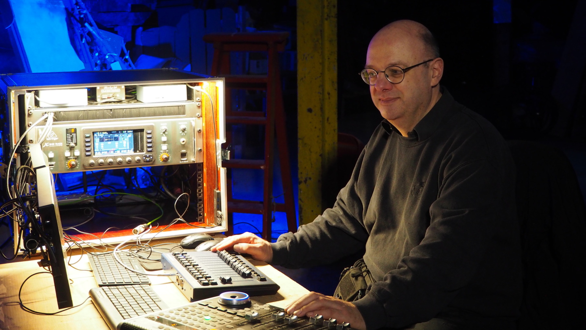 Tom sat at his sound and lighting desk smiling