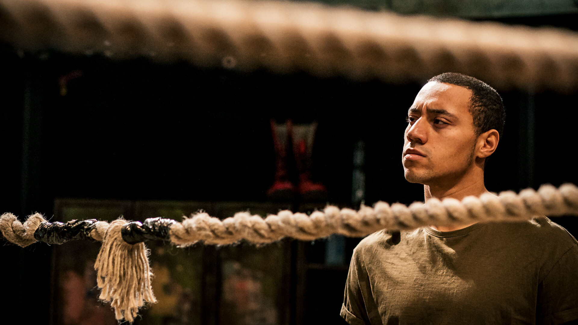 A man behind wrestling ring ropes