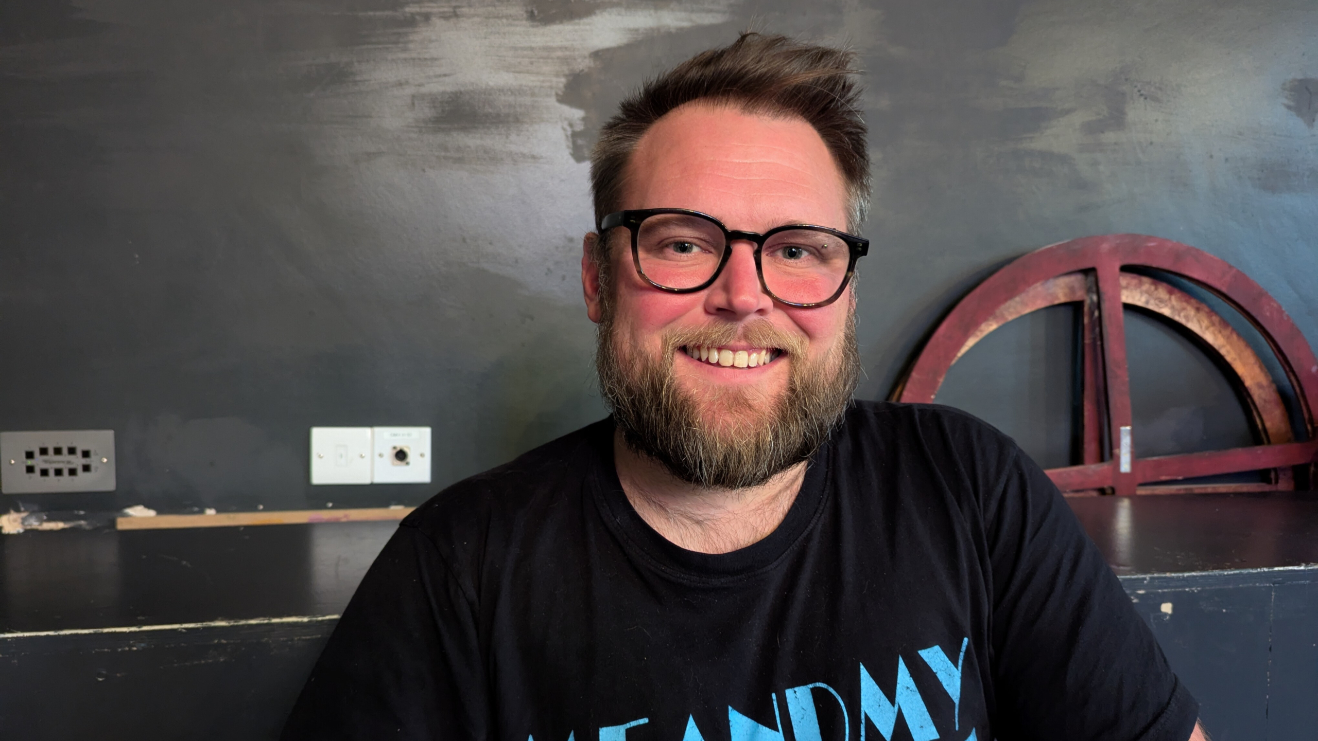 A man with a beard and glasses smiling