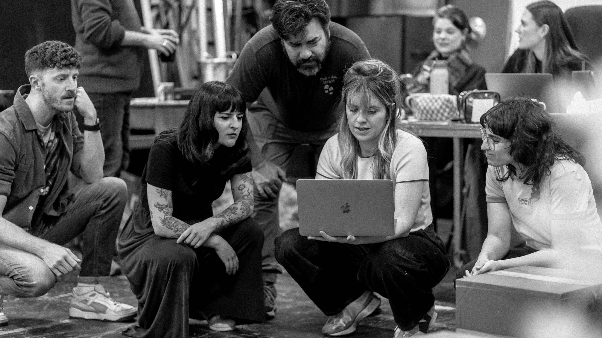 The team crouched down and looking at a laptop