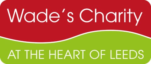 Wade's Charity at the heart of logo on a red and green background