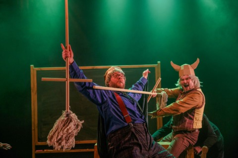 Two men playfighting with mops