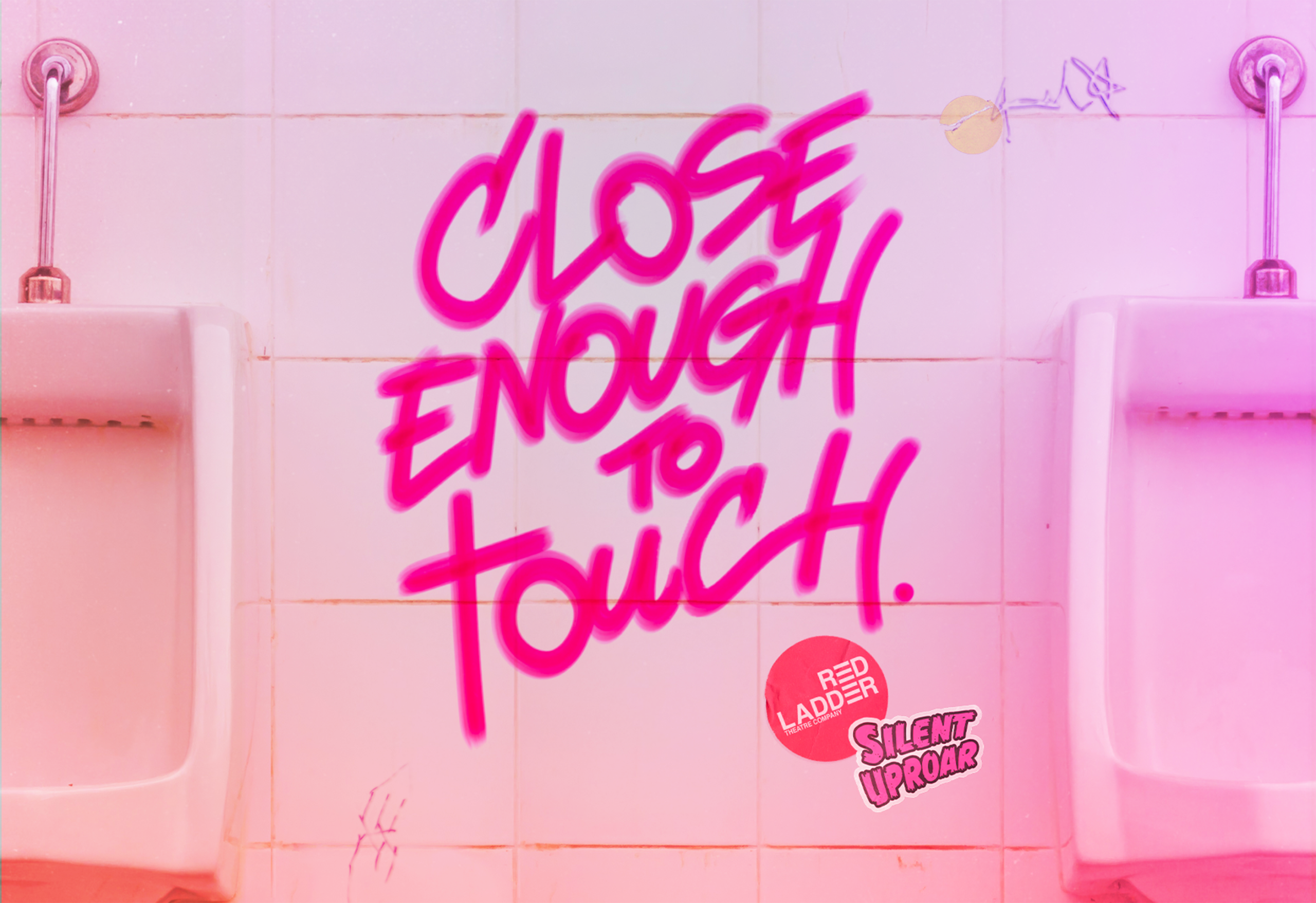 A graffiti title saying 'close enough to touch' in pink marker pen sits on the white tiles of a public toilet between two urinals