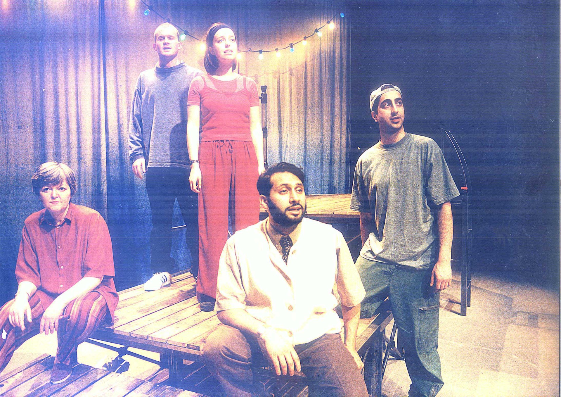 Five people on stage in front of a grey curtain