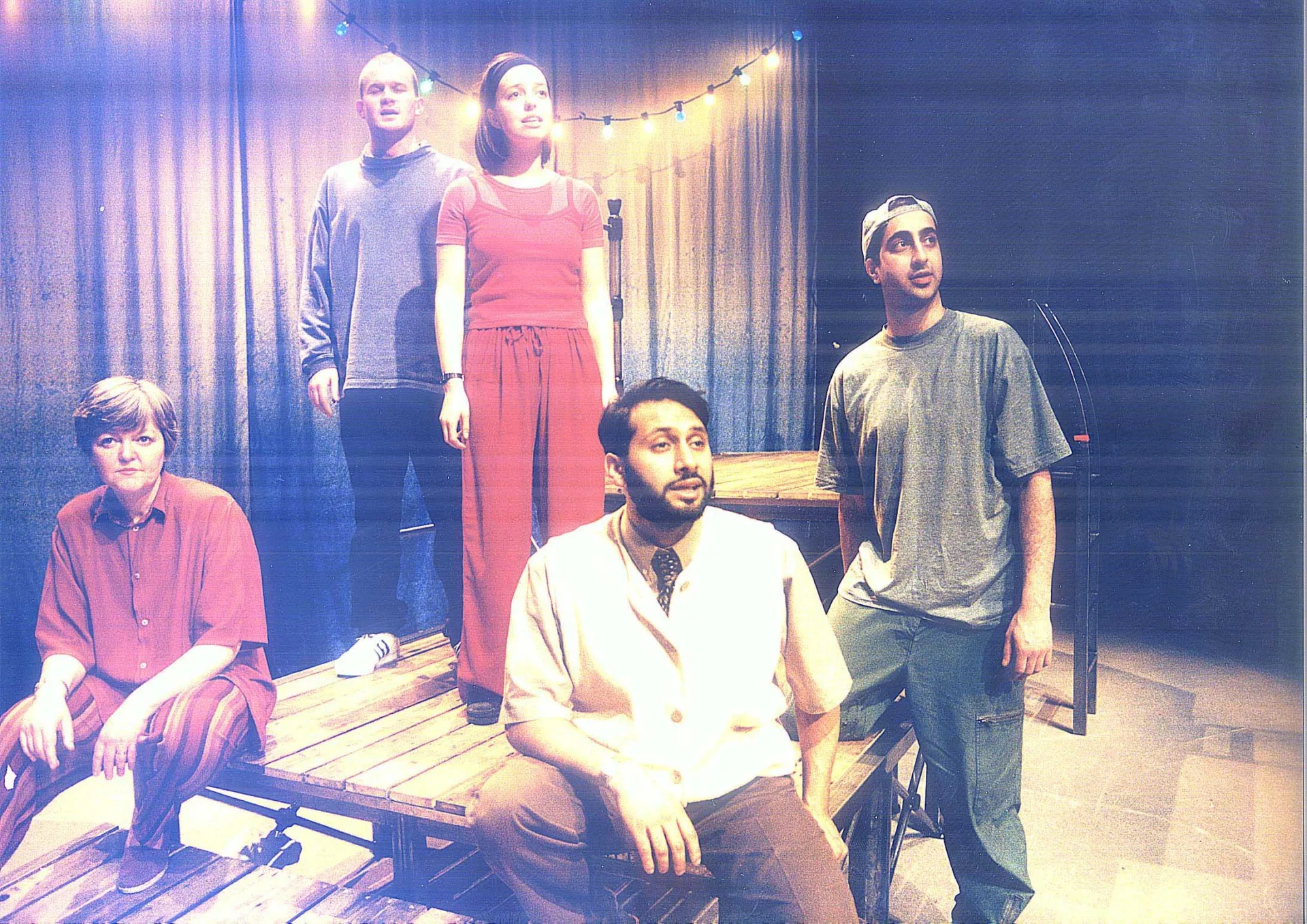 Five people on stage in front of a grey curtain