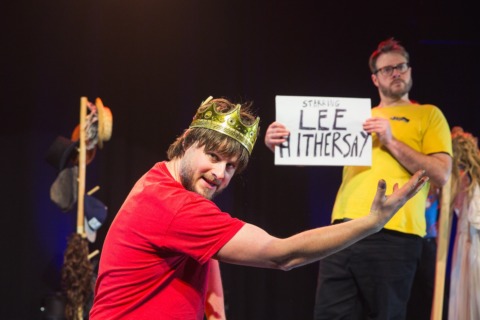 A man in a crown pointing to a sign reading Lee Hithersay