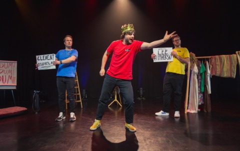 A man in a toy crown gesturing left