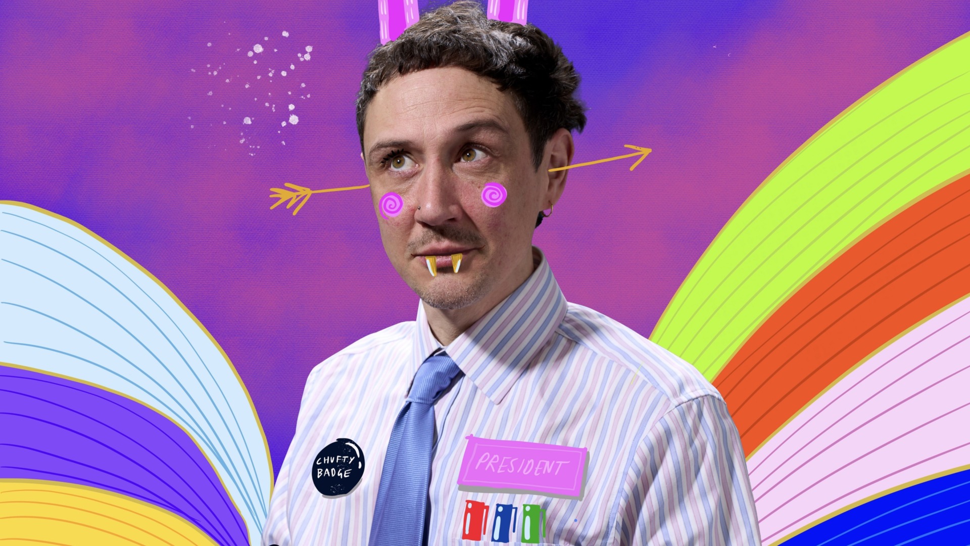 Scott with drawn on fangs, rabbit ears and googly eyes with a rainbow background