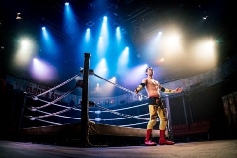 A wrestler peacocking on edge of ring