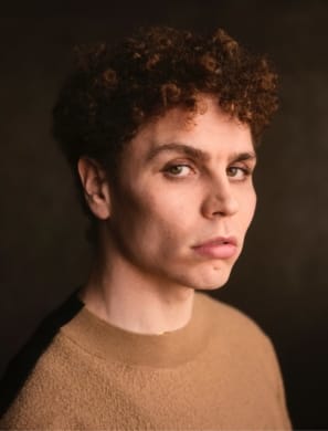 Stefan in a beige jumper looking seriously to camera