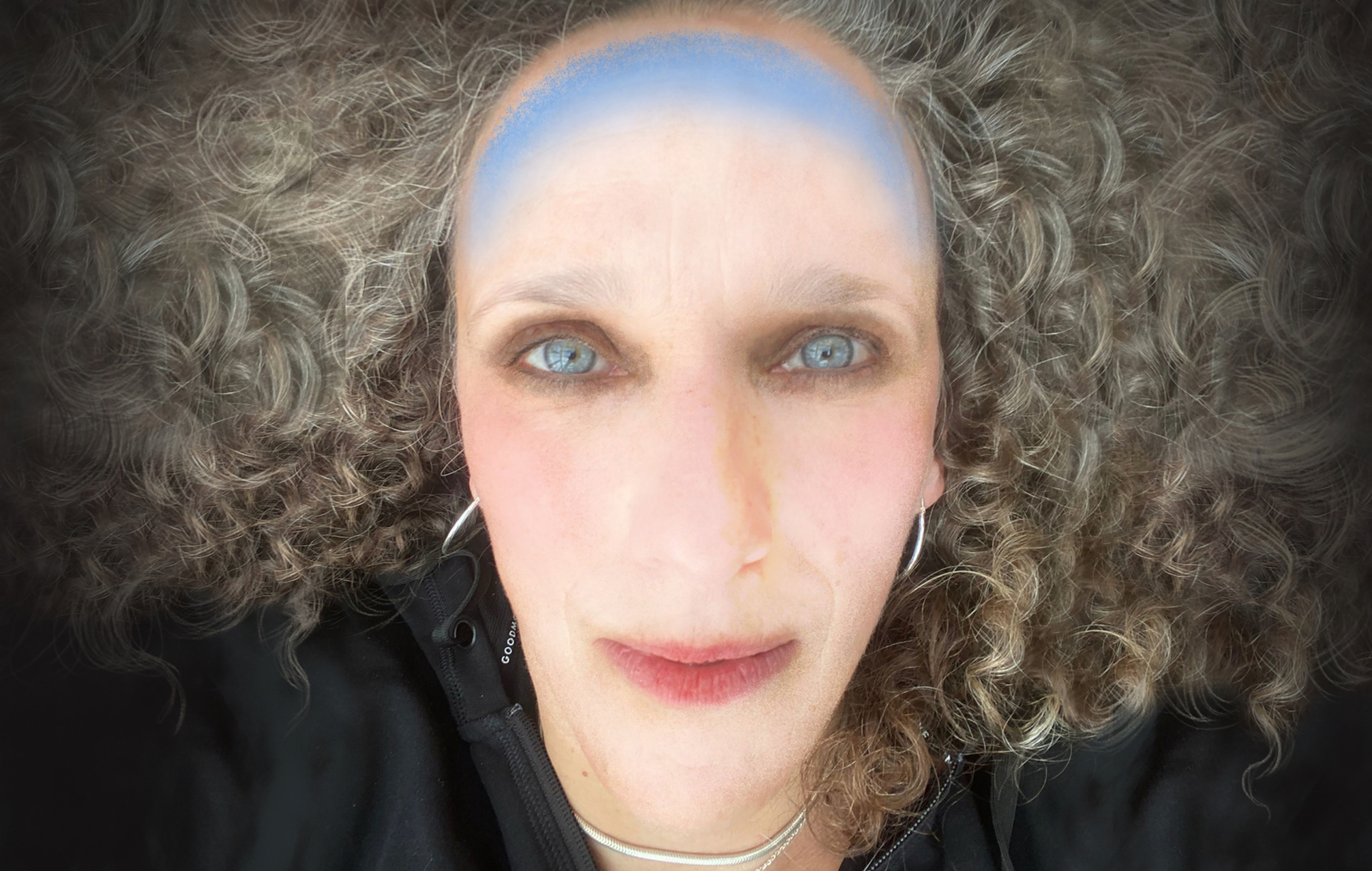 A woman with hair splayed out and a blue band drawn on her head