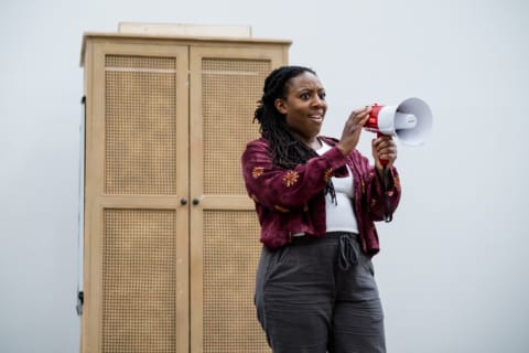 Alicia holding a megaphone on stage