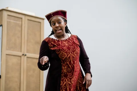 Alicia in a tabard and hat