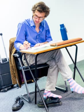 Henry making notes at his desk in rehearsal room