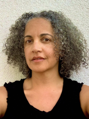 Jane in a black vest against an outside wall