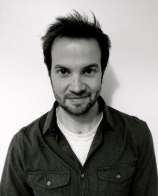 Mark smiling against a white wall